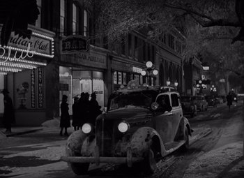 Movie still from “It's a Wonderful Life” (1946), directed by Frank Capra – An old car driving down a street at night; Extreme Wide shot, High angle
