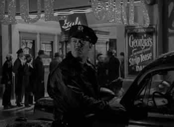 Movie still from “It's a Wonderful Life” (1946), directed by Frank Capra – Black and white photograph of a police officer in uniform; Medium shot, Low angle