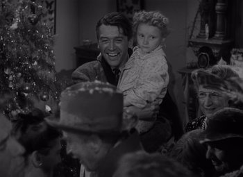 Movie still from “It's a Wonderful Life” (1946), directed by Frank Capra – A man holding a little girl in his arms; Medium shot, Over the shoulder angle