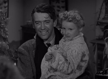 Movie still from “It's a Wonderful Life” (1946), directed by Frank Capra – A man holding a little girl in her arms; Medium shot, Over the shoulder angle