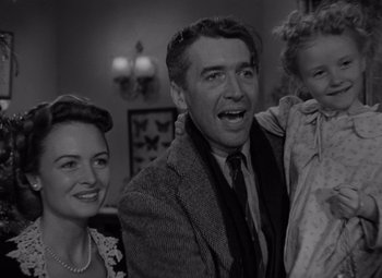 Movie still from “It's a Wonderful Life” (1946), directed by Frank Capra – An old photo of a man and a woman and a little girl; Medium shot, Low angle