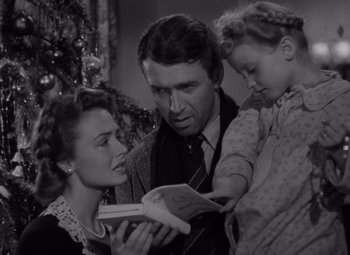 Movie still from “It's a Wonderful Life” (1946), directed by Frank Capra – An old photo of a man and a woman and a little girl; Medium shot, Low angle