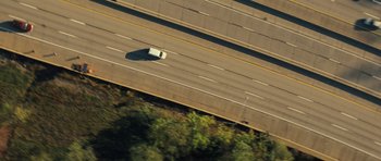 Movie still from “Jack Reacher” (2012), directed by Christopher McQuarrie – An aerial view of a white van driving down a highway; Extreme Wide shot, Overhead angle