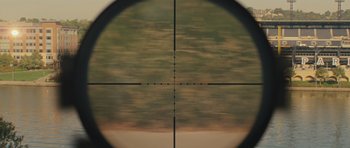 Movie still from “Jack Reacher” (2012), directed by Christopher McQuarrie – A rifle scope with a sky background; Extreme Close Up shot, High angle