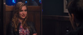 Movie still from “Jack Reacher” (2012), directed by Christopher McQuarrie – A woman sitting on a wooden bench in front of a wooden wall; Close Up shot, Over the shoulder angle