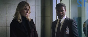 Movie still from “Jack Reacher” (2012), directed by Christopher McQuarrie – A man and a woman standing next to each other; Medium shot, Over the shoulder angle