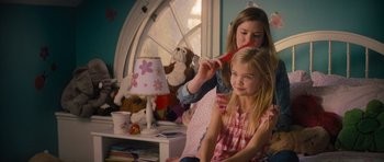 Movie still from “Jack Reacher” (2012), directed by Christopher McQuarrie – A young girl sitting in front of a window brushing her hair; Medium shot, Over the shoulder angle