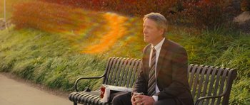 Movie still from “Jack Reacher” (2012), directed by Christopher McQuarrie – A man sitting on top of a park bench holding a cup; Medium shot, High angle