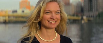 Movie still from “Jack Reacher” (2012), directed by Christopher McQuarrie – A woman wearing a black shirt and a pearl necklace; Close Up shot, High angle