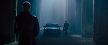 Movie still from “Jack Reacher” (2012), directed by Christopher McQuarrie – A man walking down a street with a car in the background; Wide shot, Over the shoulder angle