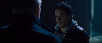 Movie still from “Jack Reacher” (2012), directed by Christopher McQuarrie – A man in a black jacket is talking to another man in a blue jacket; Close Up shot, Over the shoulder angle