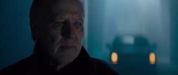 Movie still from “Jack Reacher” (2012), directed by Christopher McQuarrie – An old man with a gray beard stares into the camera; Close Up shot, Over the shoulder angle