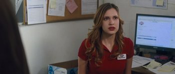Movie still from “Jack Reacher” (2012), directed by Christopher McQuarrie – A woman in a red shirt is sitting in a room; Close Up shot, Over the shoulder angle