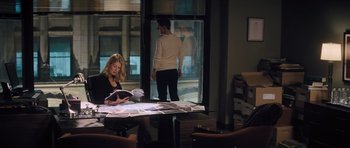 Movie still from “Jack Reacher” (2012), directed by Christopher McQuarrie – A woman sitting at a table reading a book; Wide shot, High angle