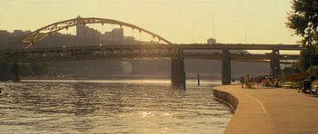 Movie still from “Jack Reacher” (2012), directed by Christopher McQuarrie – A bridge over a river with a city in the background; Extreme Wide shot, High angle