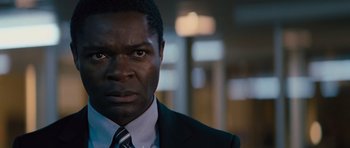 Movie still from “Jack Reacher” (2012), directed by Christopher McQuarrie – A person wearing a suit and tie; Close Up shot, Over the shoulder angle