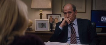 Movie still from “Jack Reacher” (2012), directed by Christopher McQuarrie – A man in a suit and tie sitting at a table; Close Up shot, Over the shoulder angle