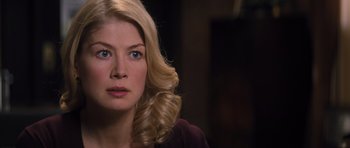 Movie still from “Jack Reacher” (2012), directed by Christopher McQuarrie – A woman with blonde hair sitting in front of a dark background; Close Up shot, Over the shoulder angle