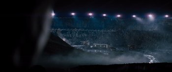 Movie still from “Jack Reacher” (2012), directed by Christopher McQuarrie – A view of an open pit at night with lights on; Extreme Wide shot, High angle