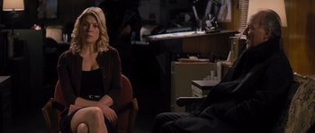 Movie still from “Jack Reacher” (2012), directed by Christopher McQuarrie – A woman sitting on a chair in front of a man; Medium shot, Over the shoulder angle