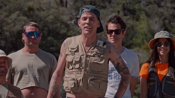 Movie still from “Jackass 4.5” (2022), directed by Jeff Tremaine – A group of men standing next to each other; Medium shot, Over the shoulder angle