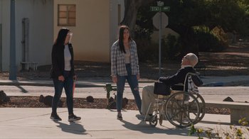 Movie still from “Jackass 4.5” (2022), directed by Jeff Tremaine – A man sitting in a wheel chair next to two women; Wide shot, Over the shoulder angle