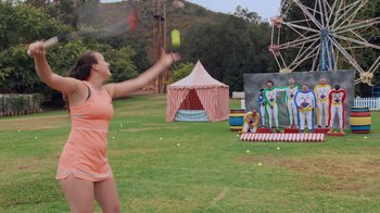 Movie still from “Jackass 4.5” (2022), directed by Jeff Tremaine – A woman is throwing a tennis ball in the air; Wide shot, Over the shoulder angle