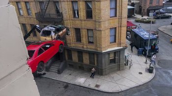 Movie still from “Jackass 4.5” (2022), directed by Jeff Tremaine – A car that is falling off of the side of a building; Extreme Wide shot, High angle