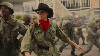 Movie still from “Jackass 4.5” (2022), directed by Jeff Tremaine – A man in a cowboy hat and a red bandanna is walking through a crowd; Medium shot, Over the shoulder angle