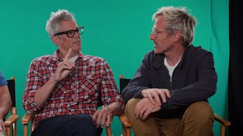 Movie still from “Jackass 4.5” (2022), directed by Jeff Tremaine – Two men are sitting in a chair and talking to each other; Medium shot, Over the shoulder angle