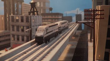 Movie still from “Jackass 4.5” (2022), directed by Jeff Tremaine – A train on the tracks in the city; Extreme Wide shot, High angle