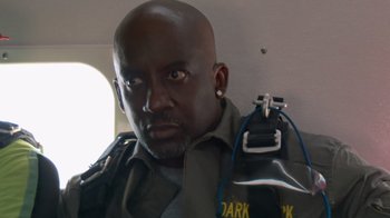 Movie still from “Jackass 4.5” (2022), directed by Jeff Tremaine – A man in a uniform holding a bag in his hand; Close Up shot, High angle