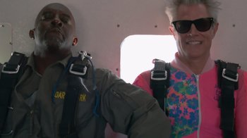 Movie still from “Jackass 4.5” (2022), directed by Jeff Tremaine – A man and a woman in a helicopter; Medium shot, Overhead angle