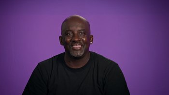 Movie still from “Jackass 4.5” (2022), directed by Jeff Tremaine – A man with a shaved head smiles for the camera; Close Up shot, Low angle