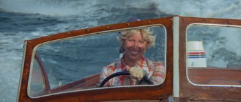 Movie still from “Jaws 2” (1978), directed by Jeannot Szwarc – A woman is driving a boat in the water; Close Up shot, High angle