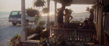Movie still from “Jaws 2” (1978), directed by Jeannot Szwarc – Two people standing on a porch near a body of water; Wide shot, Over the shoulder angle