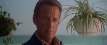 Movie still from “Jaws 2” (1978), directed by Jeannot Szwarc – A person wearing a jacket near a tree; Close Up shot, Over the shoulder angle