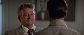 Movie still from “Jaws 2” (1978), directed by Jeannot Szwarc – A man wearing a tie talking to another man in a suit; Close Up shot, Over the shoulder angle