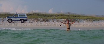 Movie still from “Jaws 2” (1978), directed by Jeannot Szwarc – A man standing in the ocean with his arms outstretched; Wide shot, Low angle