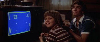Movie still from “Jaws 2” (1978), directed by Jeannot Szwarc – A young boy sitting in front of a television; Close Up shot, Over the shoulder angle