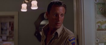 Movie still from “Jaws 2” (1978), directed by Jeannot Szwarc – A man in a police uniform looking to his left; Close Up shot, Low angle
