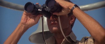 Movie still from “Jaws 2” (1978), directed by Jeannot Szwarc – A man looking through a pair of binoculars; Close Up shot, Low angle