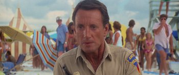 Movie still from “Jaws 2” (1978), directed by Jeannot Szwarc – A person wearing a tan shirt; Close Up shot, Over the shoulder angle