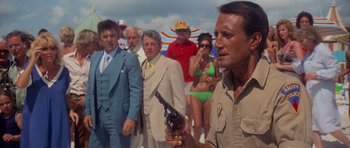 Movie still from “Jaws 2” (1978), directed by Jeannot Szwarc – A group of people standing around a man holding a gun; Medium shot, Low angle