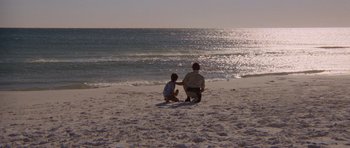Movie still from “Jaws 2” (1978), directed by Jeannot Szwarc – A man and a boy sitting on the beach; Extreme Wide shot, Over the shoulder angle