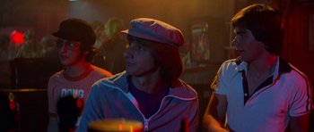 Movie still from “Jaws 2” (1978), directed by Jeannot Szwarc – A man with a hat sitting in front of a group of people; Close Up shot, Over the shoulder angle