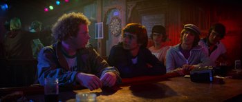 Movie still from “Jaws 2” (1978), directed by Jeannot Szwarc – A group of young men sitting at a table; Medium shot, Over the shoulder angle