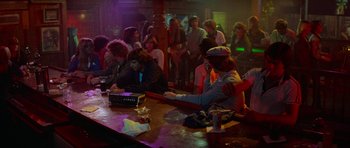 Movie still from “Jaws 2” (1978), directed by Jeannot Szwarc – A group of people sitting at a bar with drinks; Wide shot, High angle