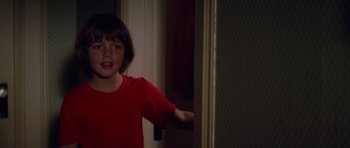 Movie still from “Jaws 2” (1978), directed by Jeannot Szwarc – A little girl in a red shirt standing next to a door; Close Up shot, Over the shoulder angle