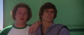 Movie still from “Jaws 2” (1978), directed by Jeannot Szwarc – Two men standing next to each other in front of a green background; Close Up shot, Low angle
